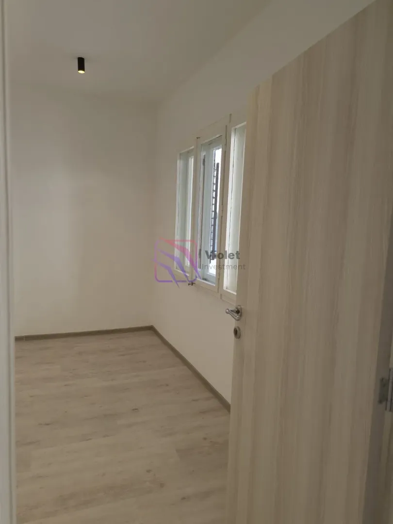 Empty unfurnished room with white walls and a wooden floor.