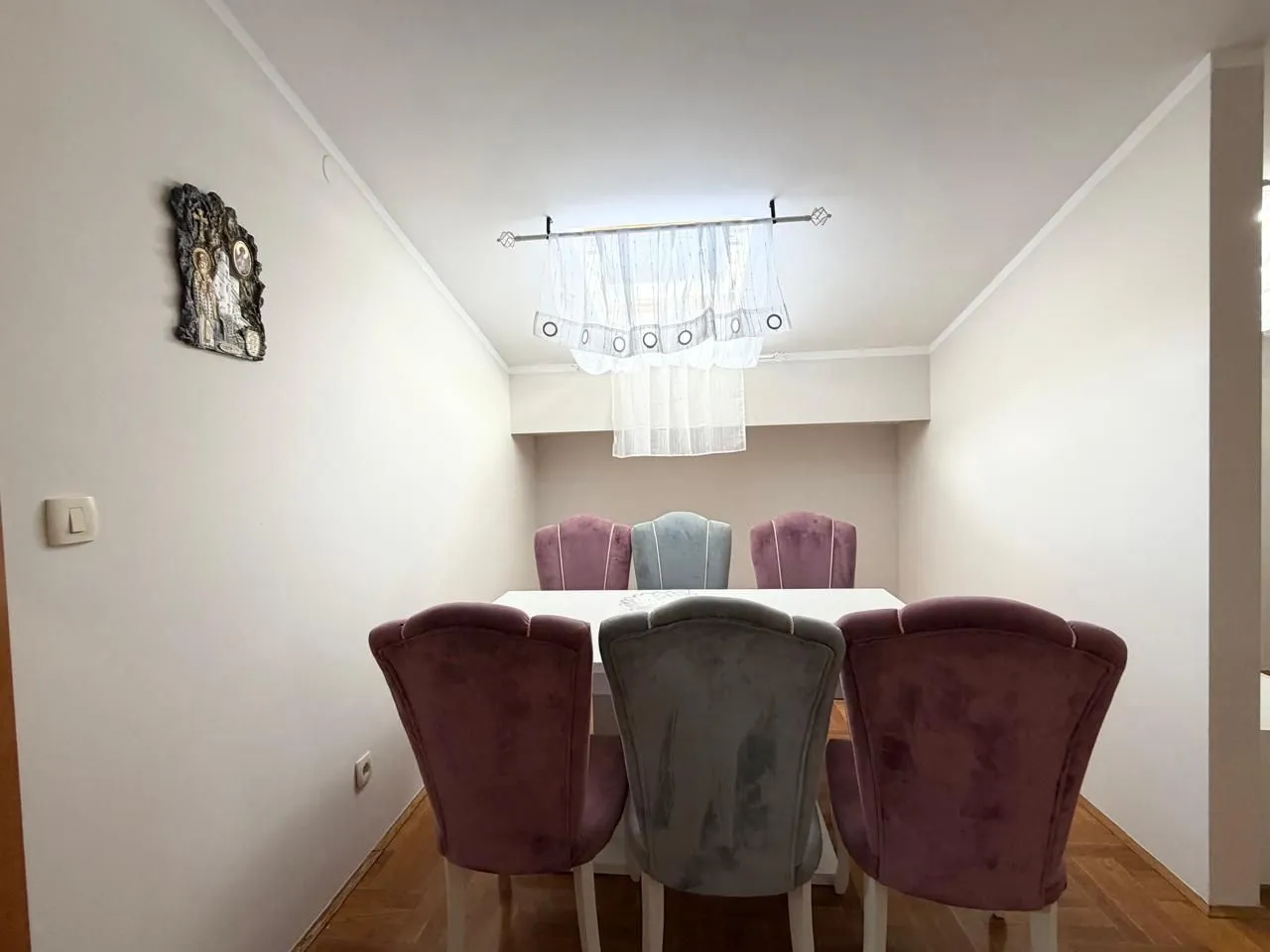 Trpezarija sa stolom i tapaciranim stolicama.