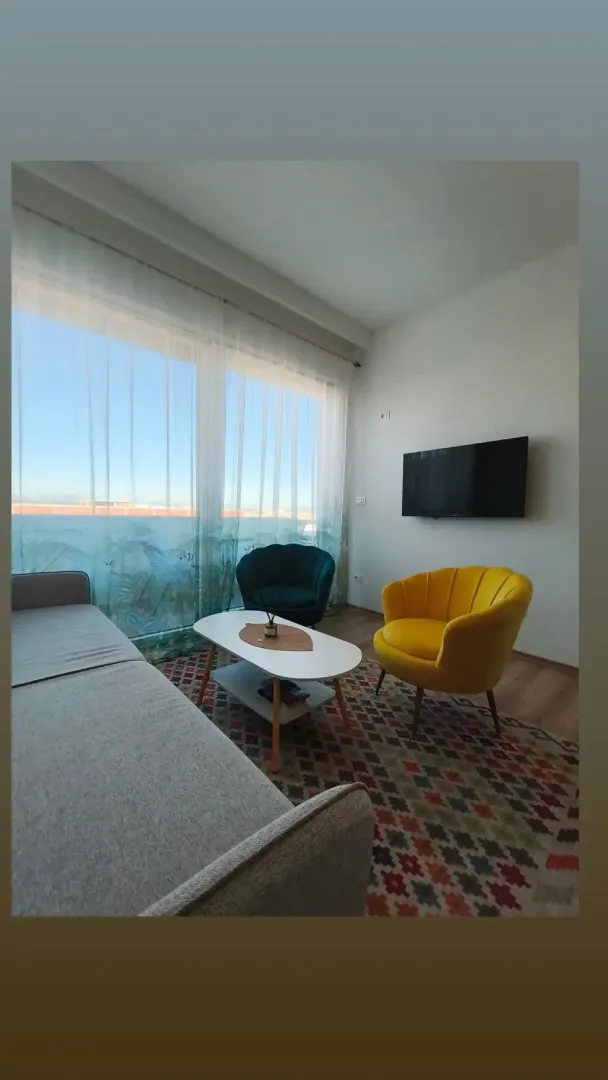 Dnevni boravak sa garniturom, foteljama i TV-om.