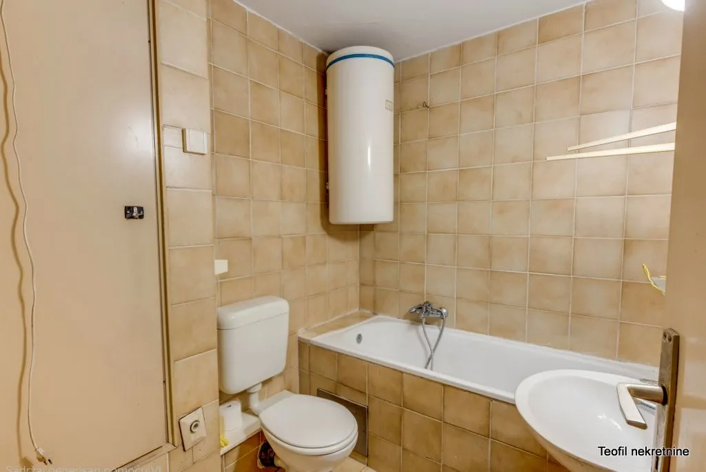 Kupatilo obloženo keramičkim pločicama sa kadom, wc šoljom, umivaonikom i bojlerom.