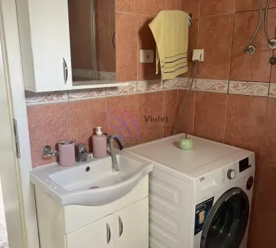 Bathroom with a washbasin, cabinet, mirror, and washing machine. - image 13