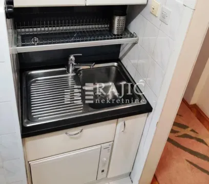 Small kitchen with a sink and cabinetry. - image 4