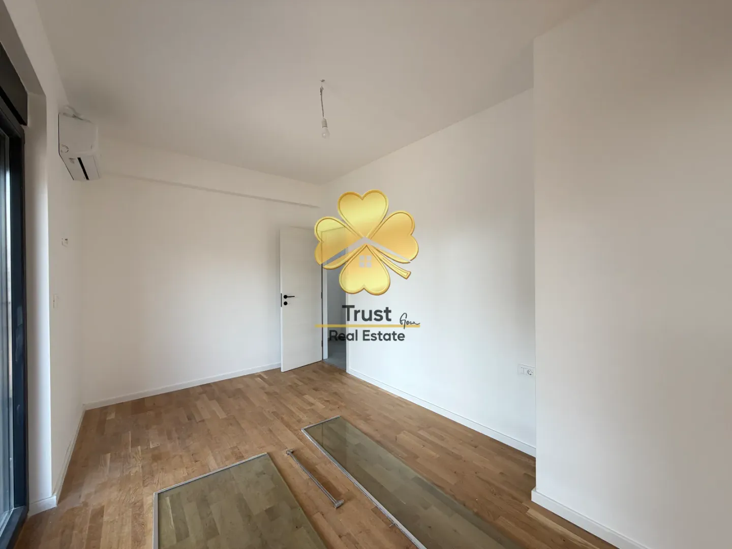 Empty room with parquet flooring and white walls.
