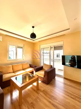 Dnevna soba sa garniturom, stočićem i televizorom na zidu. - image 5