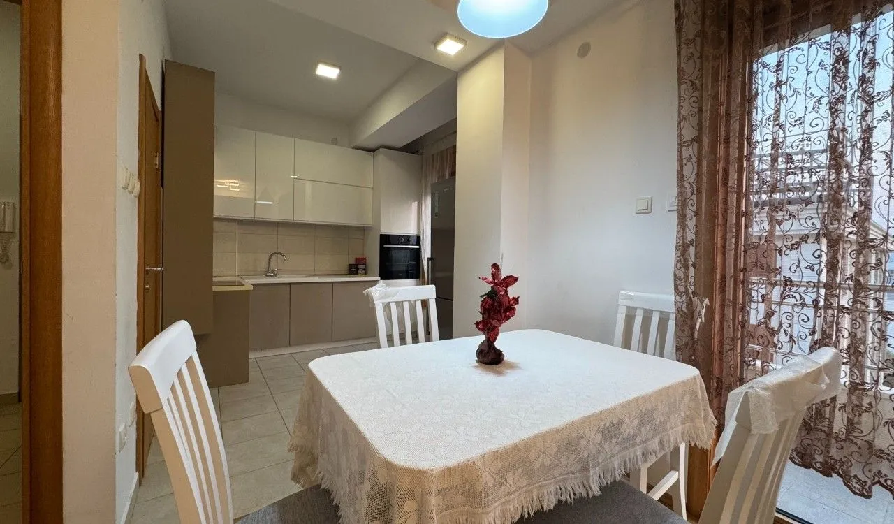 Kitchen with dining area equipped with white cabinetry and a dining table.