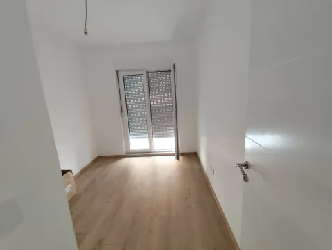 Empty unfurnished room with wooden flooring and balcony doors. - image 10