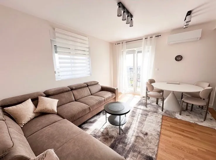 Living room with a sectional sofa, coffee table, and dining table with chairs.