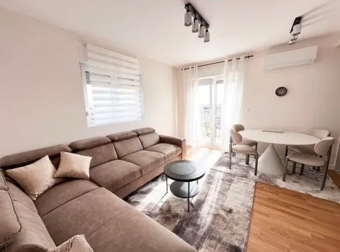 Living room with a sectional sofa, coffee table, and dining table with chairs. - image 3