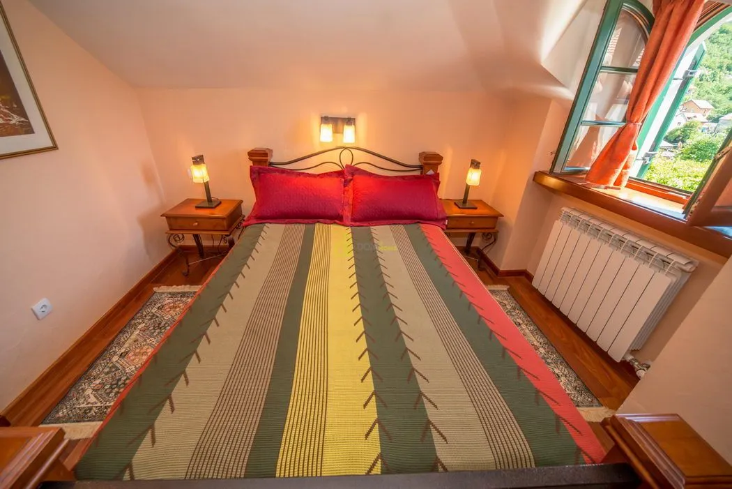 Furnished bedroom with a double bed, bedside tables and a window.
