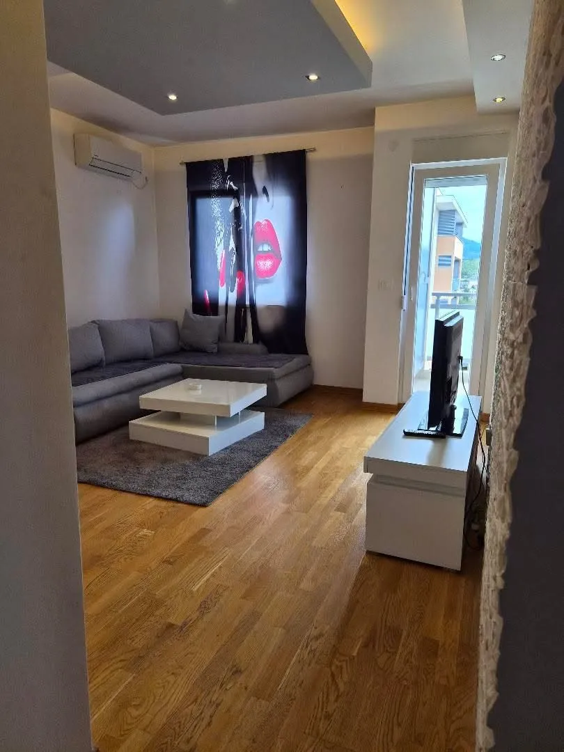Living room with a sofa, TV, and access to the terrace.