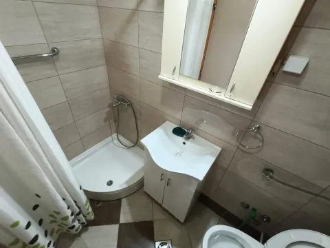 Kompaktno kupatilo opremljeno tuš kabinom, umivaonikom sa ormarićem i ogledalom. - image 4