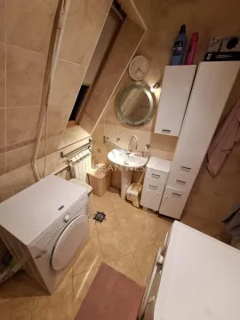 Kupatilo obloženo keramičkim pločicama sa umivaonikom, ogledalom i veš mašinom. - image 10