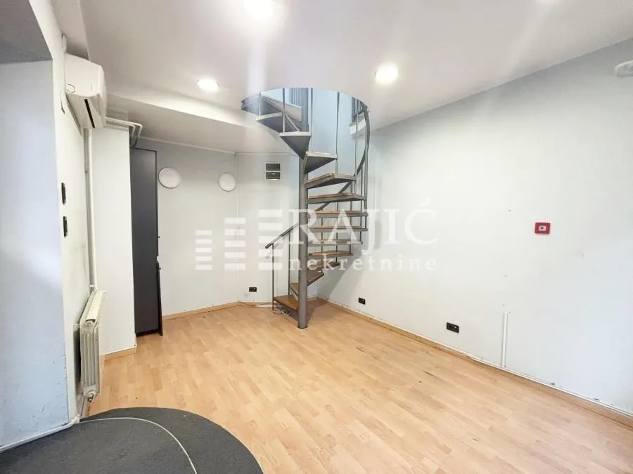 Living room with a spiral staircase and wooden flooring.