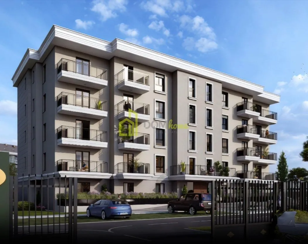 Exterior view of a modern residential building with balconies and a landscaped yard.