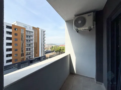 View from the balcony overlooking surrounding buildings and greenery. - image 10