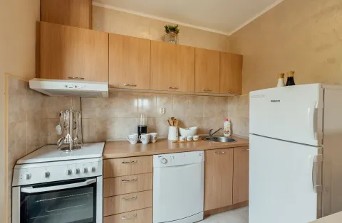 Kitchen with wooden cabinetry, stove, sink, and refrigerator. - image 4