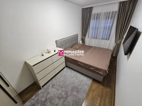 Opremljena spavaća soba sa bračnim krevetom, komodom i televizorom. - image 7