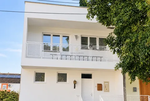 Front view of a modern white building with a terrace. - image 8