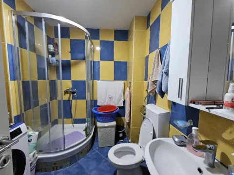 Kupatilo sa tuš kabinom i plavo-žutim pločicama. - image 6