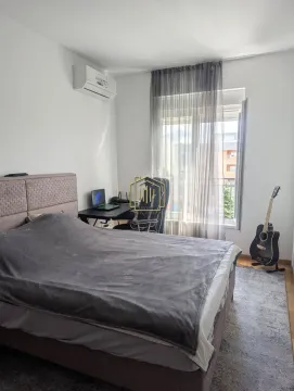 Namještena spavaća soba sa bračnim krevetom, radnim stolom i gitarom pored prozora. - image 8