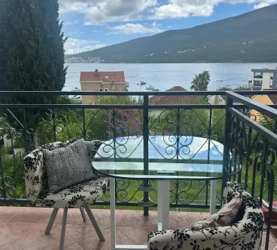 Namješten balkon sa stolom i stolicama i pogledom na more. - image 9