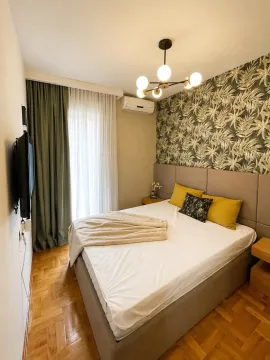Furnished bedroom with a double bed, decorative wallpaper, and air conditioning. - image 6