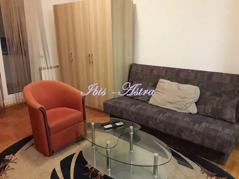 Living room with a sofa, armchair, and wardrobe.