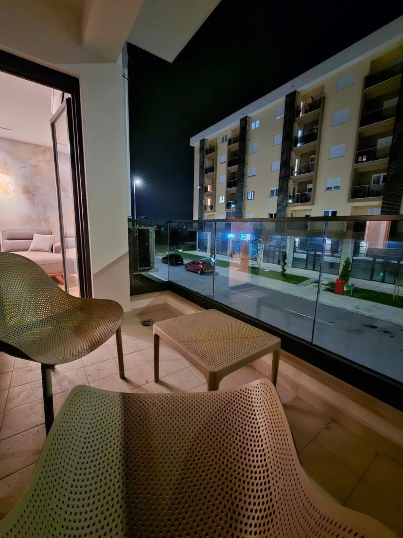 Illuminated terrace with seating furniture and a view of the building at night.
