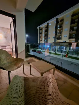 Illuminated terrace with seating furniture and a view of the building at night. - image 10