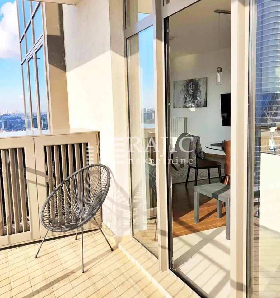 Terrace with a chair and a view into the apartment interior.