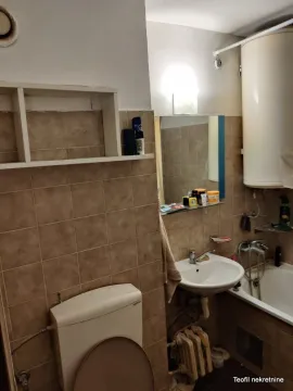 Manje kupatilo sa kadom, umivaonikom i wc šoljom obloženo keramičkim pločicama. - image 6