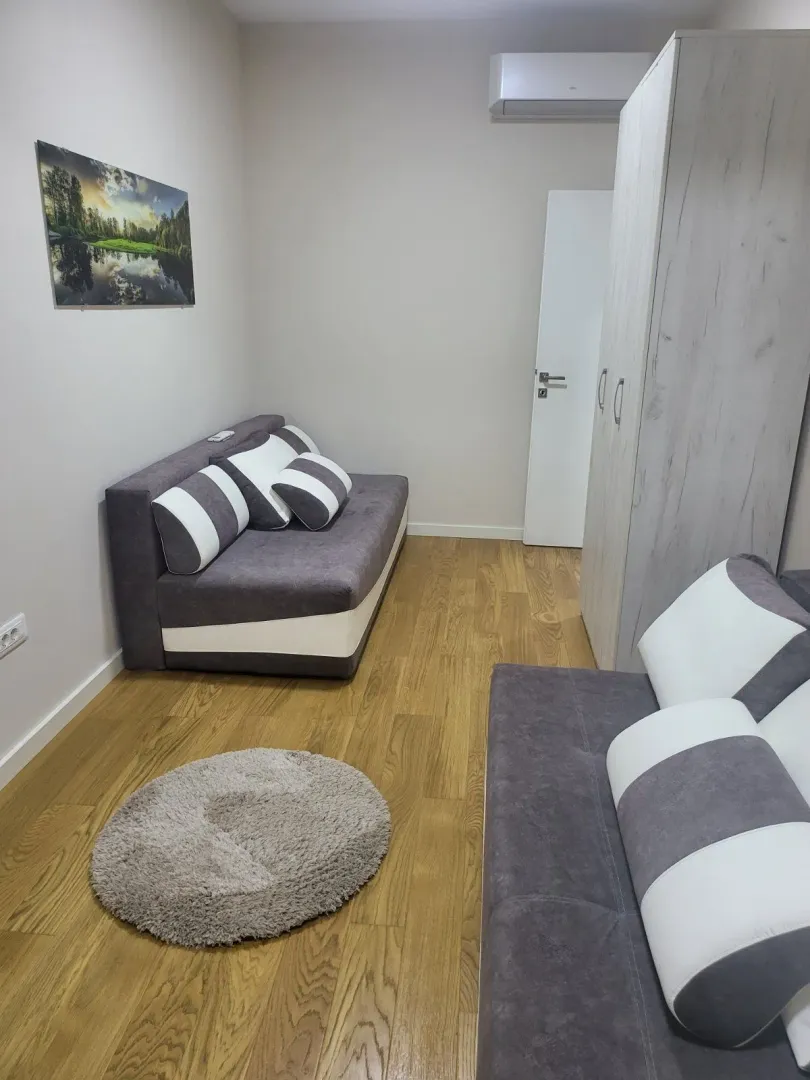 Bright living room with two sofas and wooden flooring.