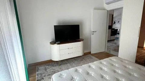 Svijetla spavaća soba sa televizorom na modernoj komodi. - image 5