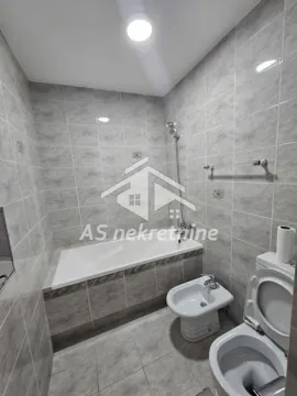 Kupatilo opremljeno kadom, bideom i WC šoljom sa sivim zidnim pločicama. - image 27