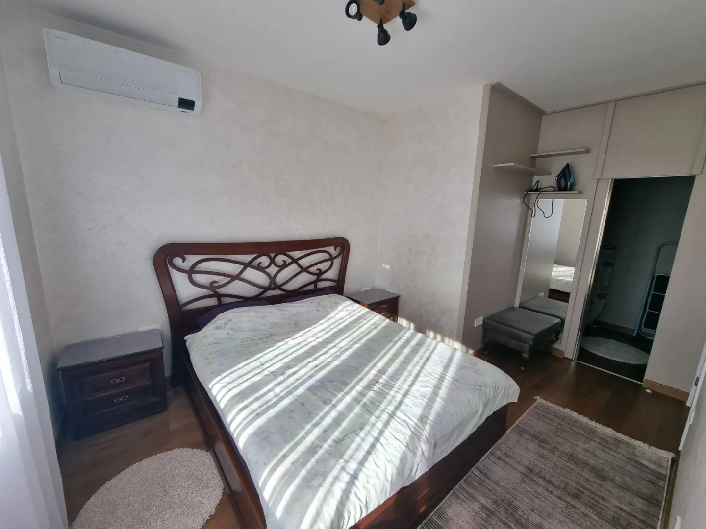 Bright bedroom with a double bed, nightstands, and a built-in wardrobe.