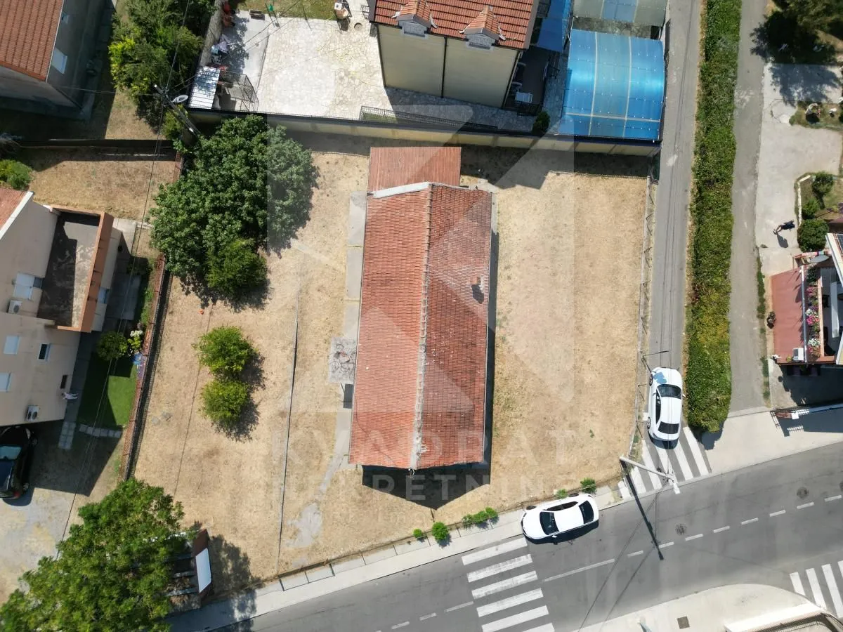 Pogled iz vazduha na kuću sa dvoriijem i okolnim putem.