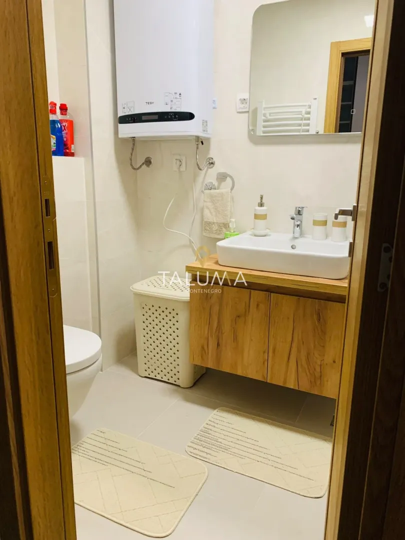 Kupatilo sa umivaonikom, ogledalom, wc šoljom i bojlerom.