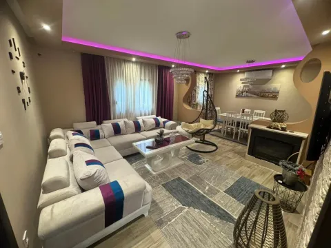 Spacious living room with a sofa set, dining area, and drop ceiling with lighting. - image 2