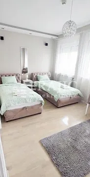 Bedroom with two single beds and white bedding. - image 18