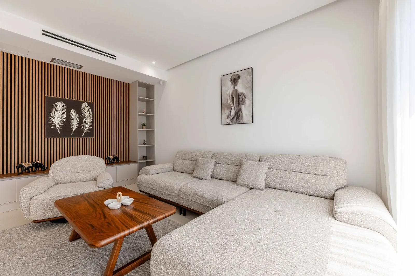 Modern living room with a sectional sofa, armchair, and wooden coffee table.
