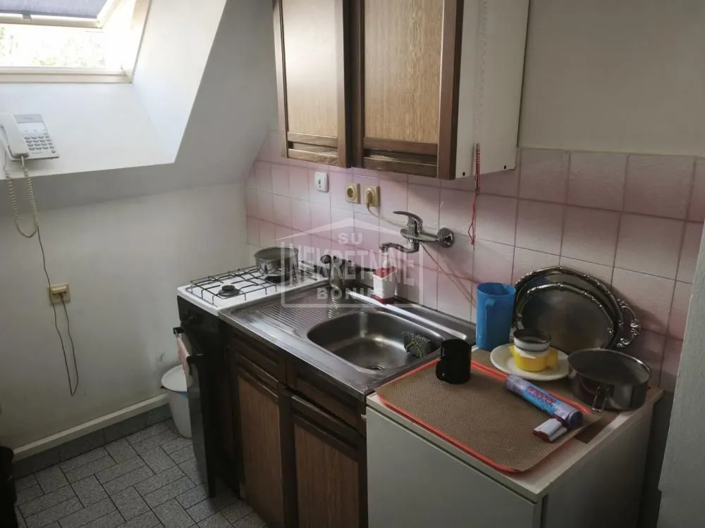 Small kitchen with a sink, stove, and wall cabinets.