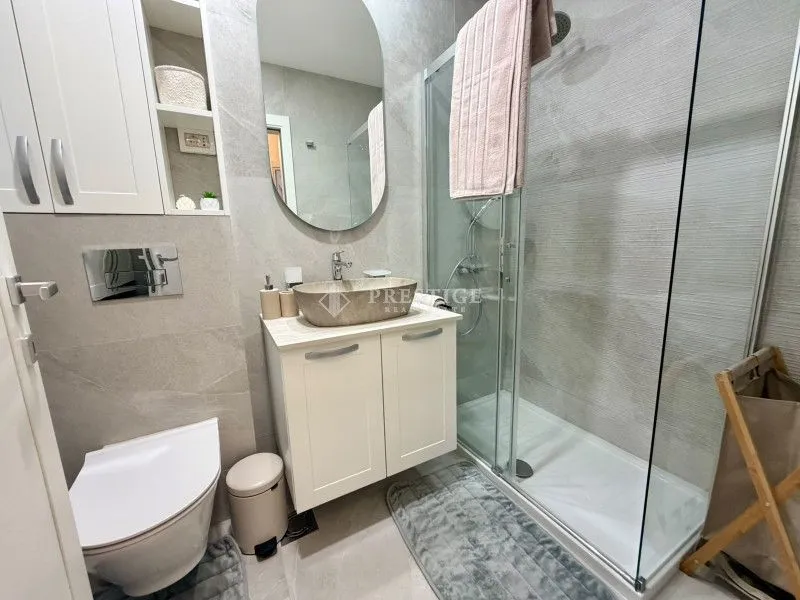 Modernly equipped bathroom with a shower cabin and a sink.