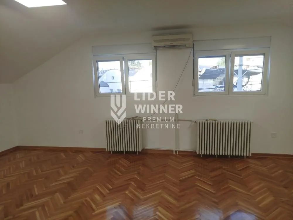Empty room with parquet flooring and white walls.