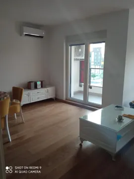 Living room with wooden flooring, white furniture, and access to the terrace. - image 2
