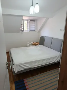 Spavaća soba sa bračnim krevetom i krovnim prozorom u potkrovlju. - image 12