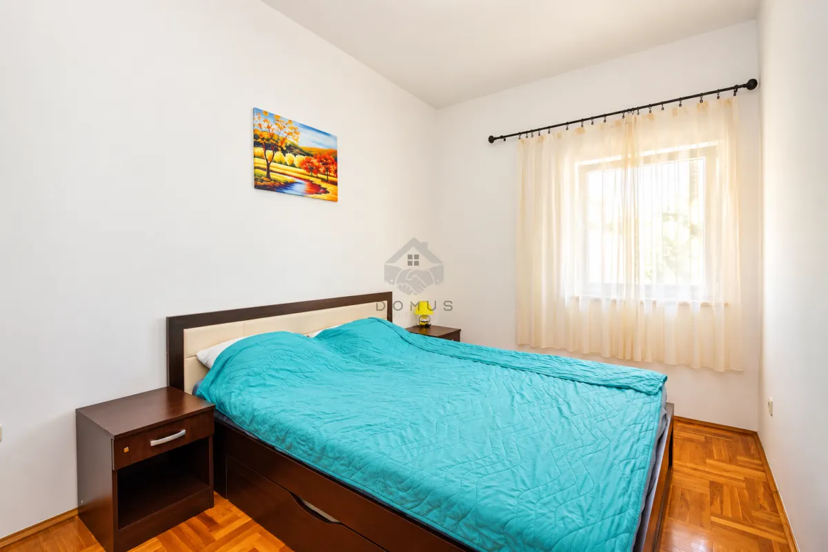 Bedroom with a double bed, nightstands, and a window with curtains.