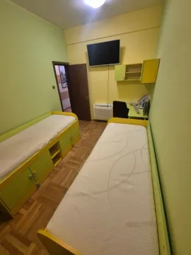 Dječja soba sa dva kreveta, radnim stolom i televizorom na zidu. - image 12