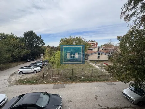 Pogled sa prozora na okolne zgrade, zelene površine i parkirana vozila. - image 14