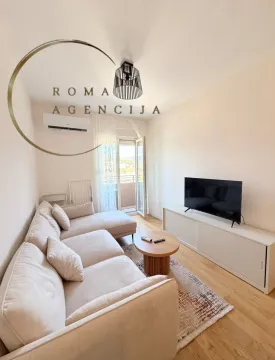 Bright living room with a sectional sofa and television. - image 3