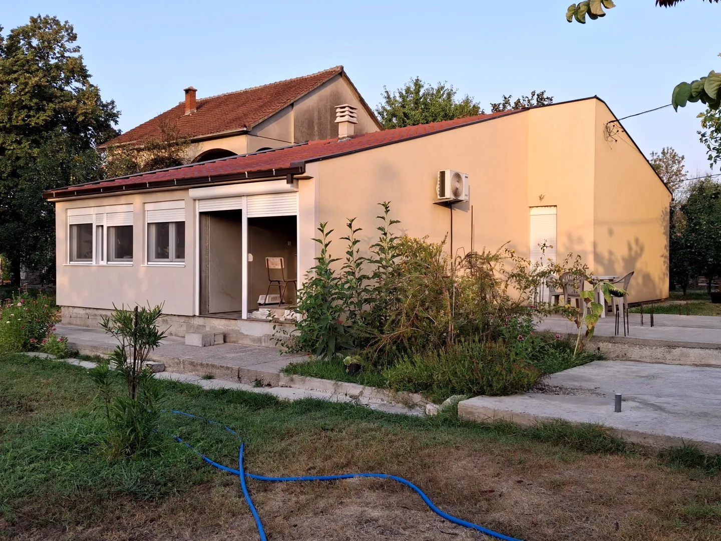 Eksterijer prizemne kuće sa dvorištem.